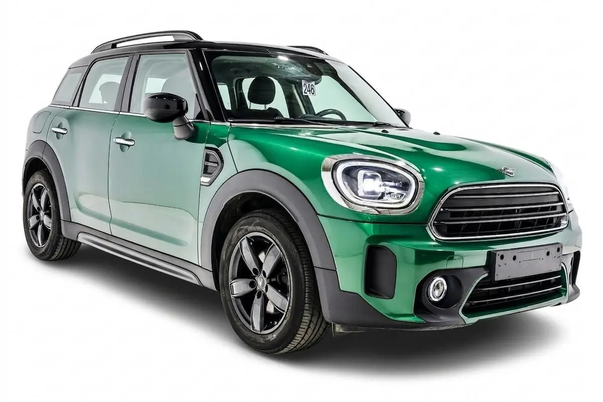 MINI Countryman vert métallisé en 3/4 avant droit, avec toit noir et jantes noires distinctives.