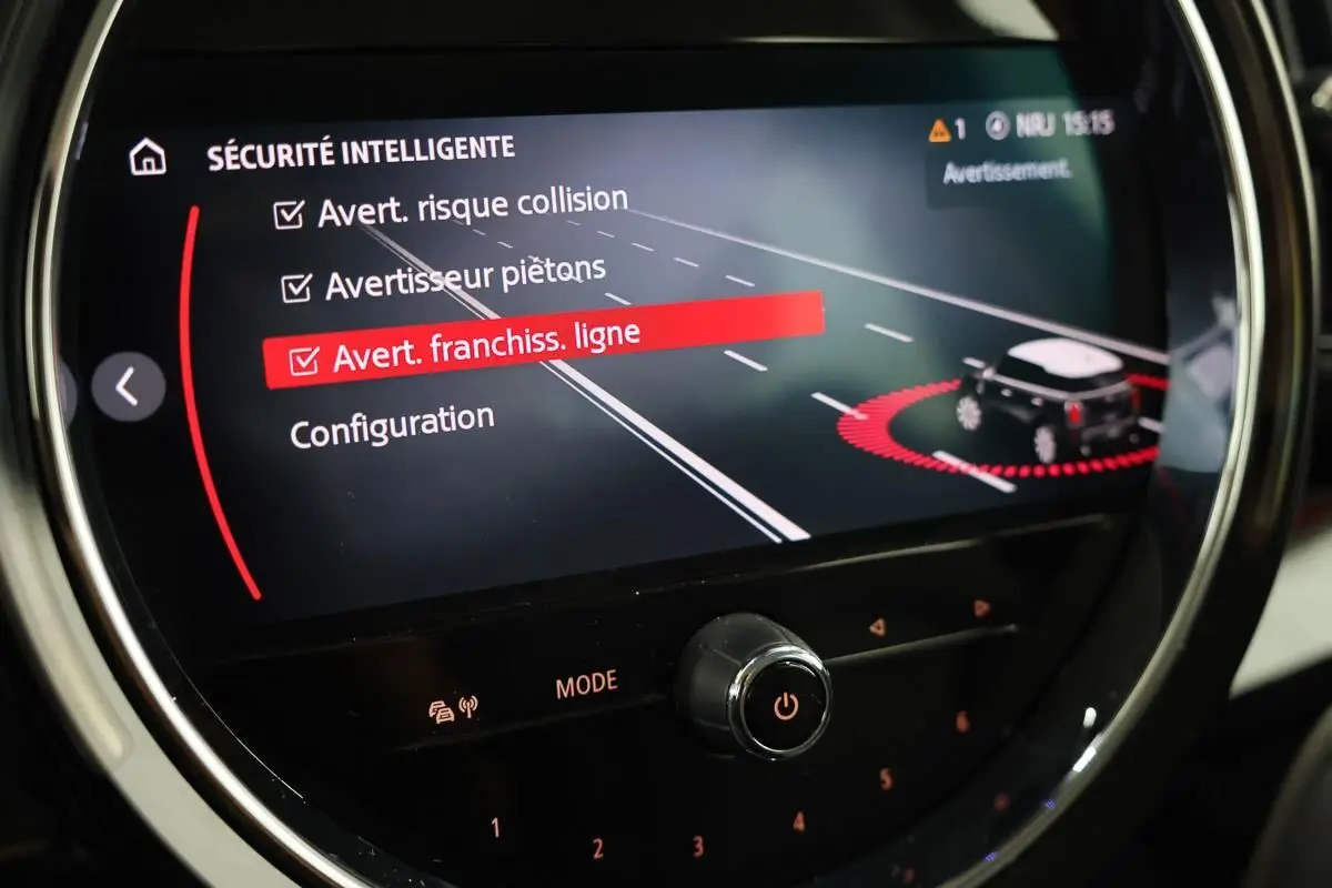Affichage du système de sécurité intelligente sur l'écran central du MINI Countryman 2021, avec alertes de collision et franchissement de ligne.