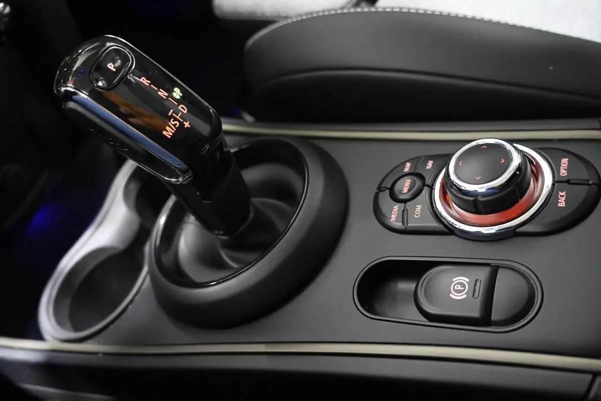 Gros plan sur la console centrale de MINI Countryman 2021, avec levier de boîte auto et commandes multimédia noires.