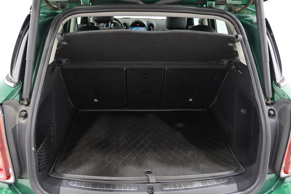 Coffre ouvert d’une MINI Countryman vert métallisé, vue arrière montrant un espace de chargement propre et spacieux.