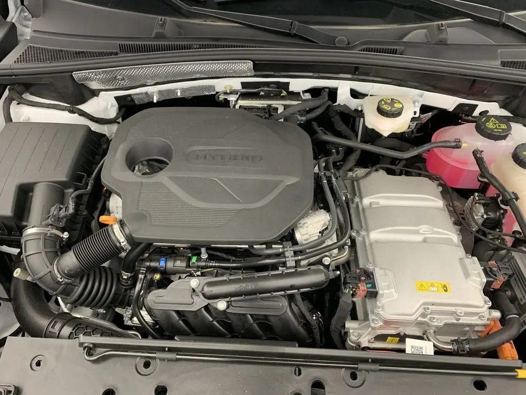 Vue rapprochée du moteur hybride du MG ZS 1.5L Hybrid+ 197CH, avec capot blanc Dover White visible autour.
