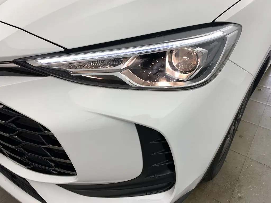 Gros plan sur le phare avant droit blanc Dover White du MG ZS 1.5L Hybrid+ 2026 avec calandre noire et détails LED.