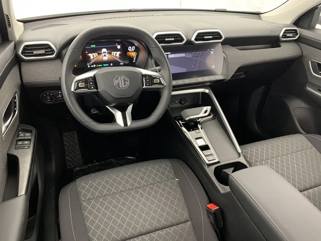 Vue intérieure du poste de conduite du MG ZS 1.5L Hybrid+ 2026, tableau de bord noir avec écran digital et volant multifonction.