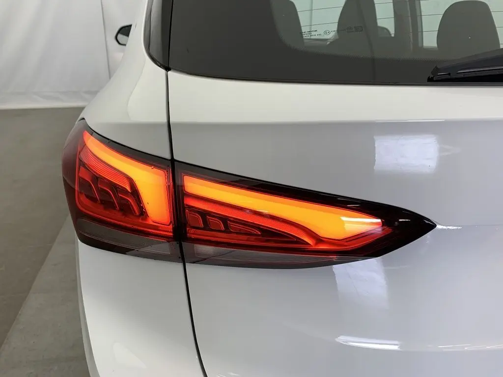Gros plan sur le feu arrière droit rouge allumé du MG ZS blanc Dover White, vue arrière partielle.