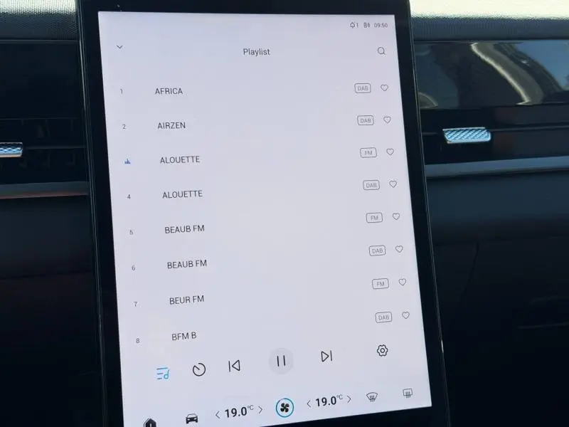 Vue rapprochée de l’écran tactile central affichant la playlist audio dans l’habitacle noir du JAECOO J5.