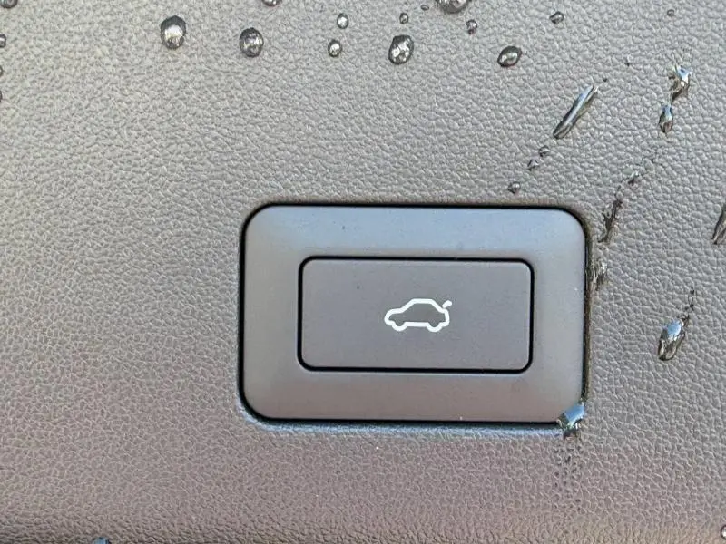 Bouton d'ouverture électrique du coffre sur tableau de bord en cuir noir du JAECOO J5 Carbon Crystal Black.