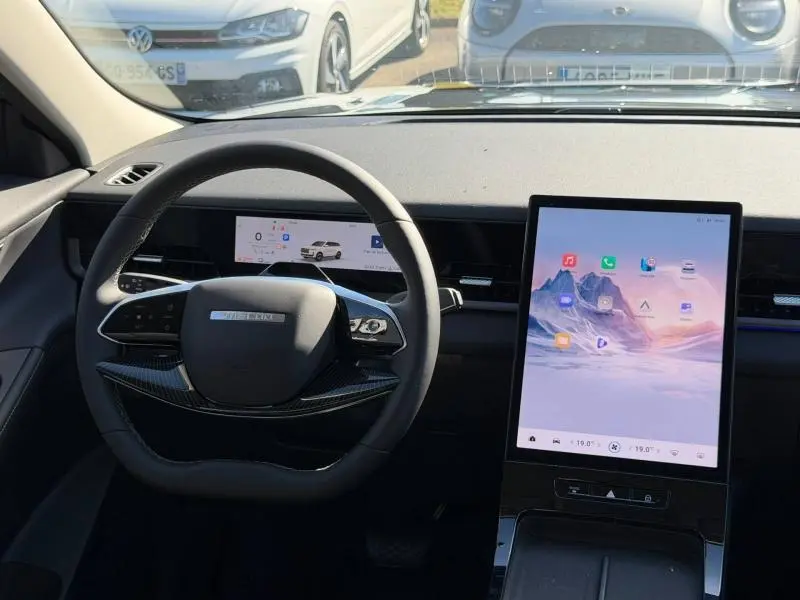Vue intérieure centrée sur le volant et l'écran tactile vertical du JAECOO J5 2026 en Carbon Crystal Black métal.