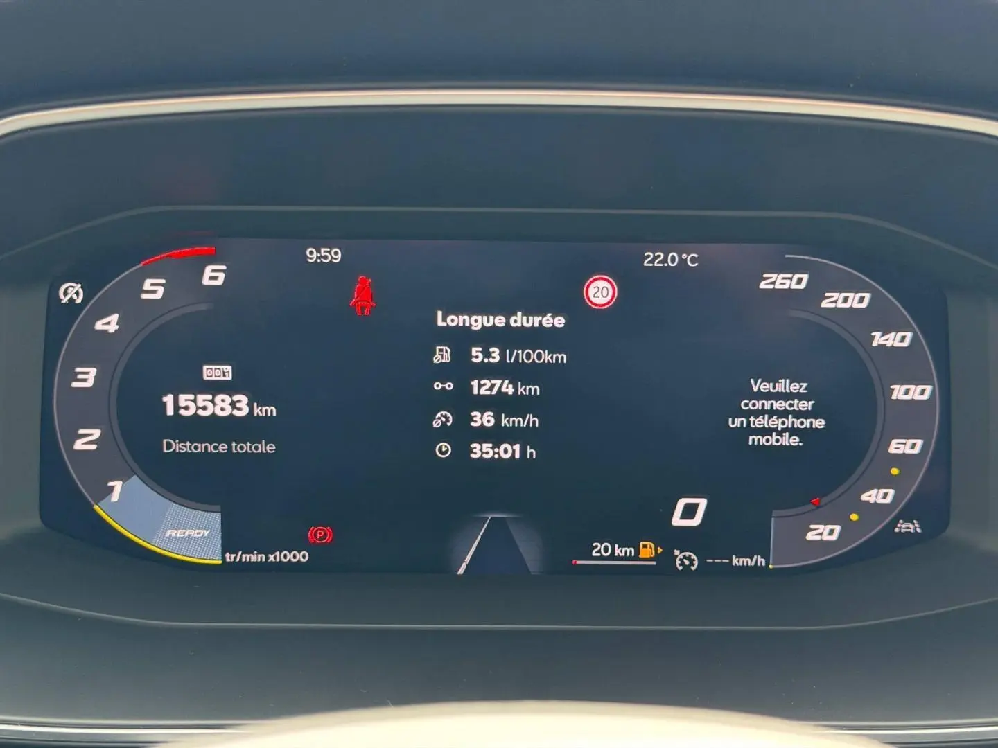 Tableau de bord numérique du SEAT Leon 2025 affichant consommation, distance, vitesse et alertes, vue frontale rapprochée.