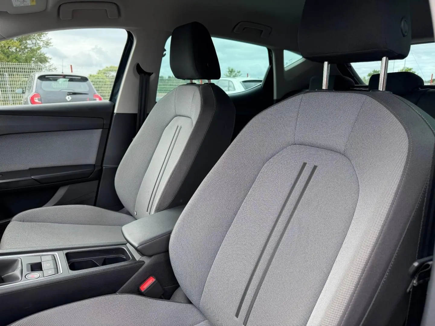 Vue intérieure côté passager avant du SEAT LEON 2.0 TDI 115ch STYLE XL avec sièges tissu gris clair et accoudoir central.