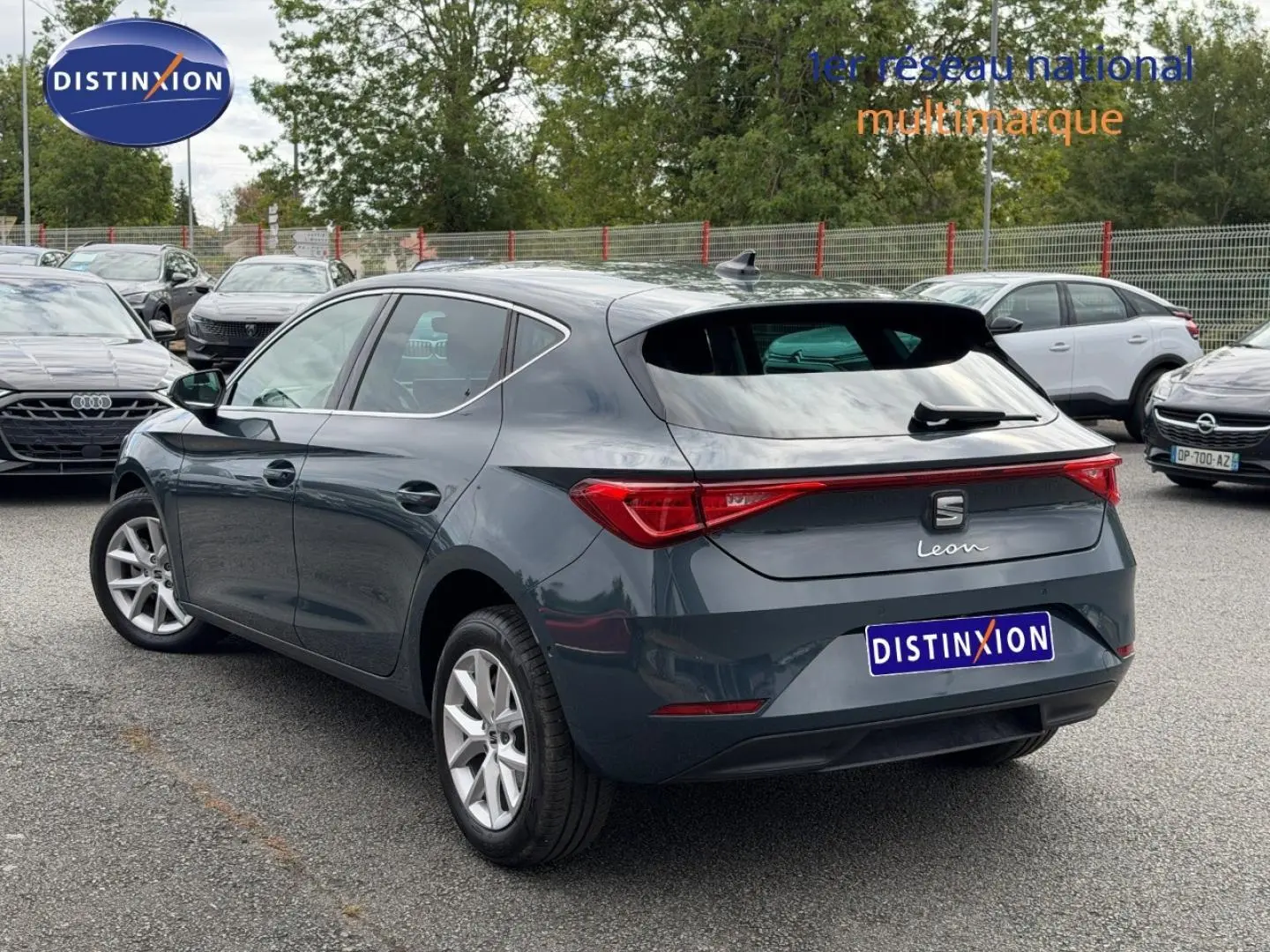 Vue 3/4 arrière droite d'une SEAT Leon gris magnétique métallisé avec feux arrière LED et jantes alu.