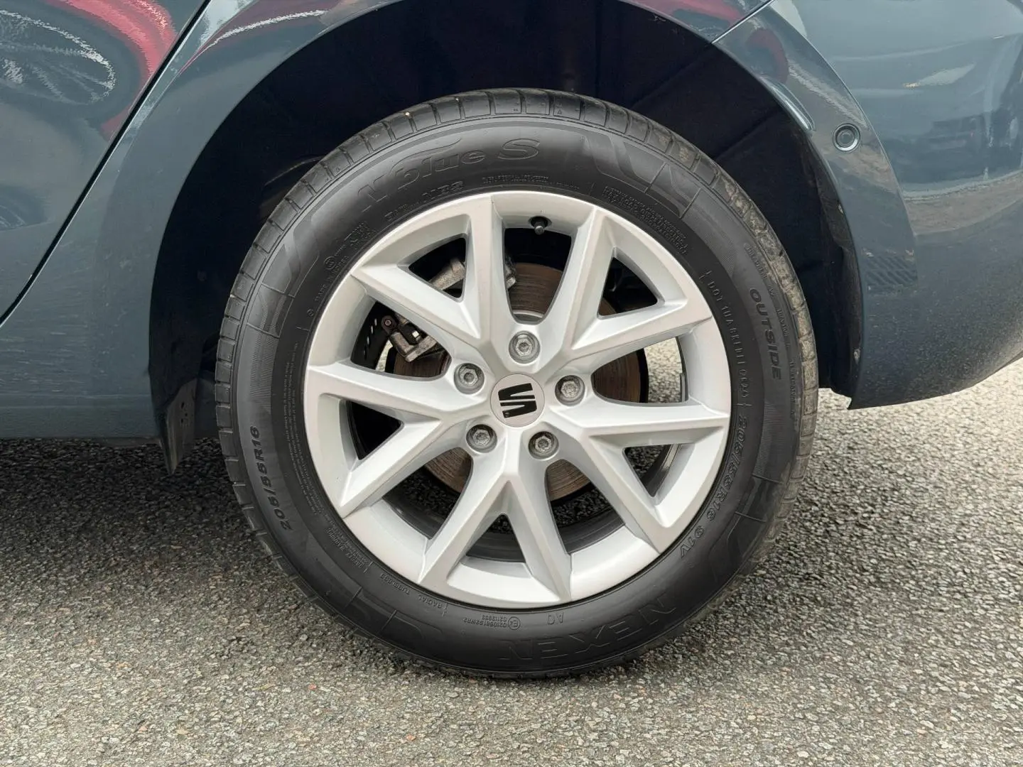 Gros plan sur la roue arrière droite de la SEAT LEON gris magnétique métallisé avec jante alu à 5 branches doubles.