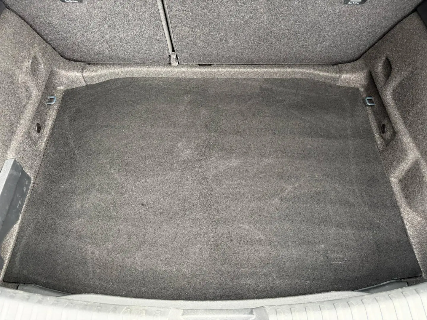 Coffre vide vu de dessus avec revêtement gris foncé dans une SEAT LEON 2.0 TDI 115ch STYLE XL 2025.