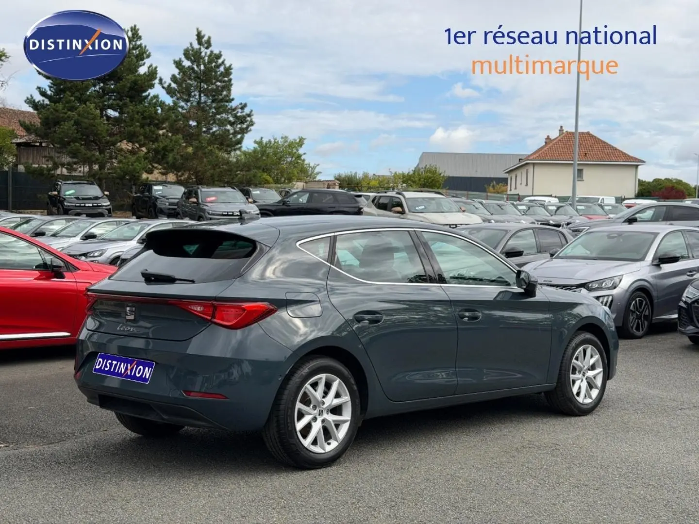 SEAT Leon 2.0 TDI gris magnétique vue 3/4 arrière droit sur parking avec jantes alu et feux LED.