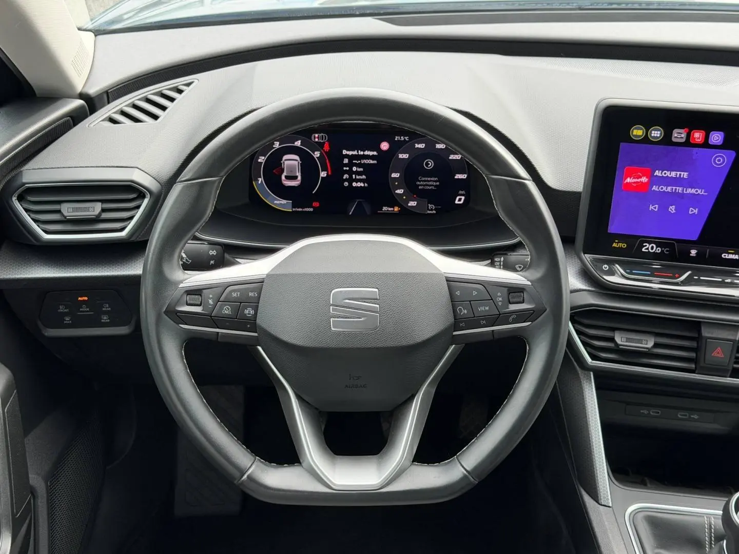 Vue rapprochée du volant cuir multifonction et du tableau de bord numérique du SEAT LEON 2.0 TDI gris Magnétique.