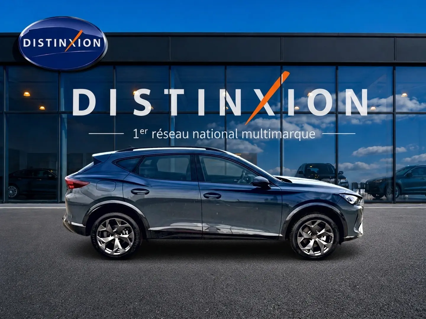Vue latérale droite d'une CUPRA Formentor 1.5 etsi hybrid bleu fjord avec jantes 18 pouces devant une vitrine Distinxion.