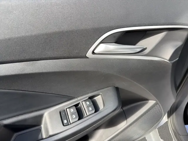 Détail de la porte intérieure côté conducteur du MG3 gris clair 2025, avec commandes des vitres et poignée argentée.