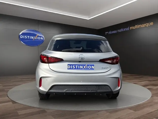 Vue arrière du MG3 gris clair 2025 avec logo MG et badge Hybrid+ Luxury, dans un showroom Distinxion.