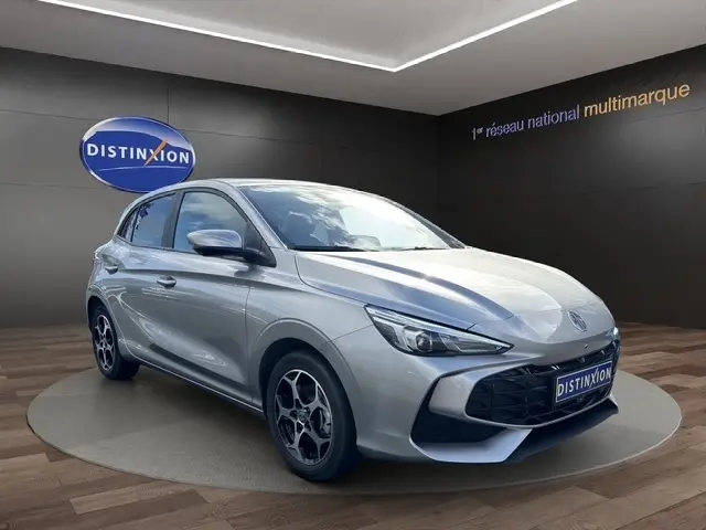 Vue 3/4 avant droite d'une MG3 gris clair 2025 avec calandre noire et jantes distinctives en concession.