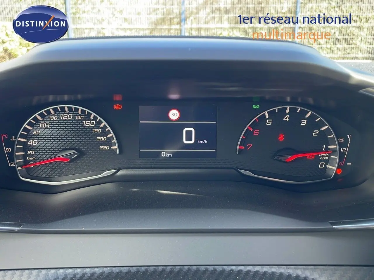 Tableau de bord numérique de Peugeot 2008 2025, affichage vitesse et compte-tours avec fond noir texturé.