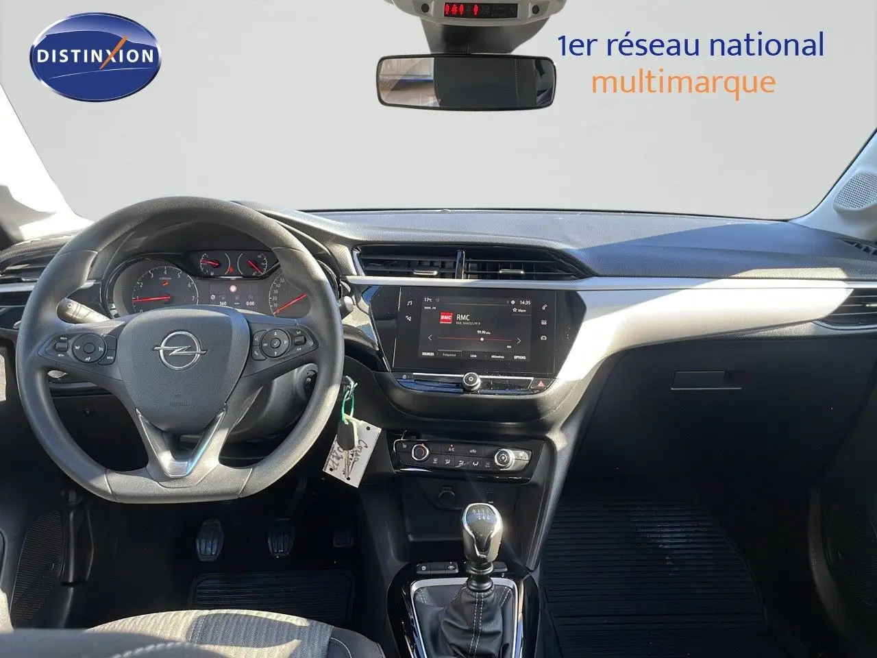 Intérieur de l'Opel Corsa blanc glacier 2022, vue frontale du poste de conduite avec volant multifonction et écran tactile central.
