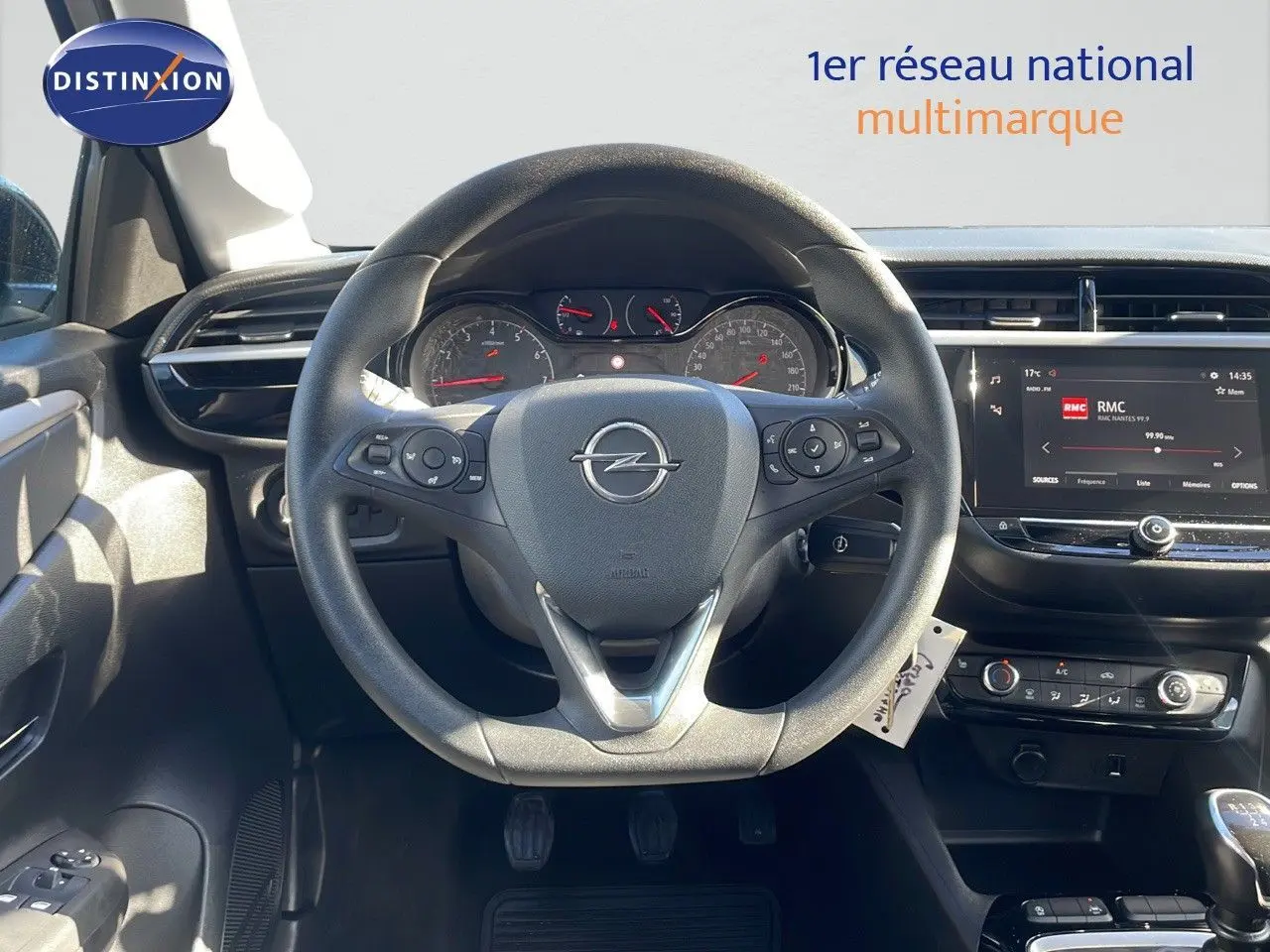 Vue intérieure centrée sur le volant Opel d'une Corsa blanche glacier 2022 avec tableau de bord digital et commandes au volant.