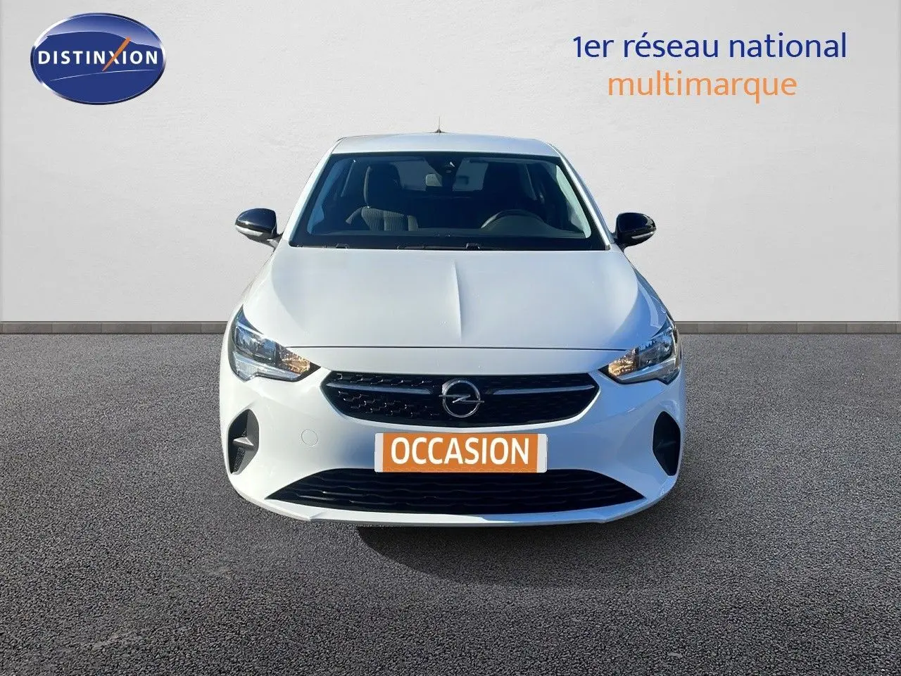 Vue frontale d'une Opel Corsa blanche glacier 2022 avec calandre noire et phares allumés sur fond neutre.