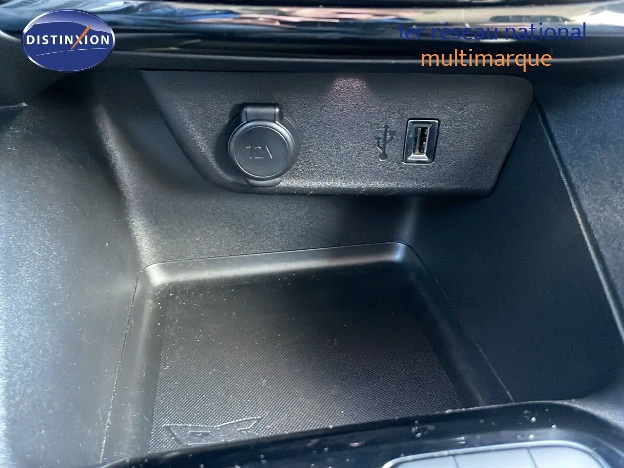 Prise 12V et port USB dans le rangement central de l'Opel Corsa blanc glacier, version 1.5D 102ch Edition 2022.