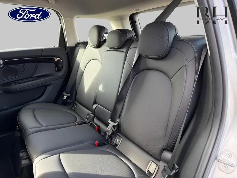 Vue intérieure des sièges arrière en similicuir noir du MINI COUNTRYMAN Melting Silver III, avec appuie-têtes et ceintures visibles.