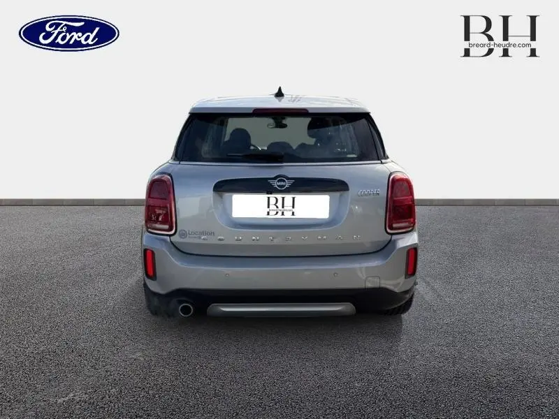 Vue arrière d'une MINI COUNTRYMAN Cooper 2023 en Melting Silver III avec feux arrière LED et sortie d'échappement chromée.