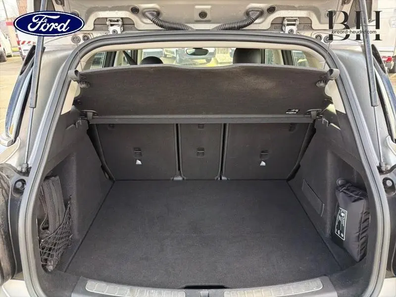 Coffre ouvert vu de l'arrière d'une MINI Countryman Melting Silver III, espace de chargement spacieux et tapis noir.