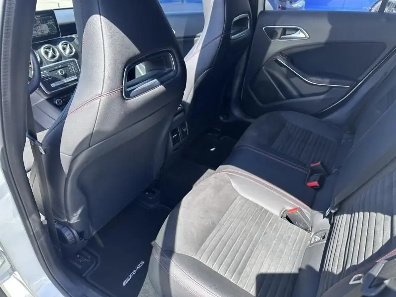 Vue intérieure arrière côté gauche d'une Mercedes Classe A 200 d Fascination 2017 avec sièges noirs et surpiqûres rouges.