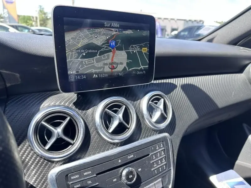 Vue intérieure du tableau de bord d’une Mercedes Classe A 200 d Fascination 2017, avec écran GPS et aérateurs ronds chromés.