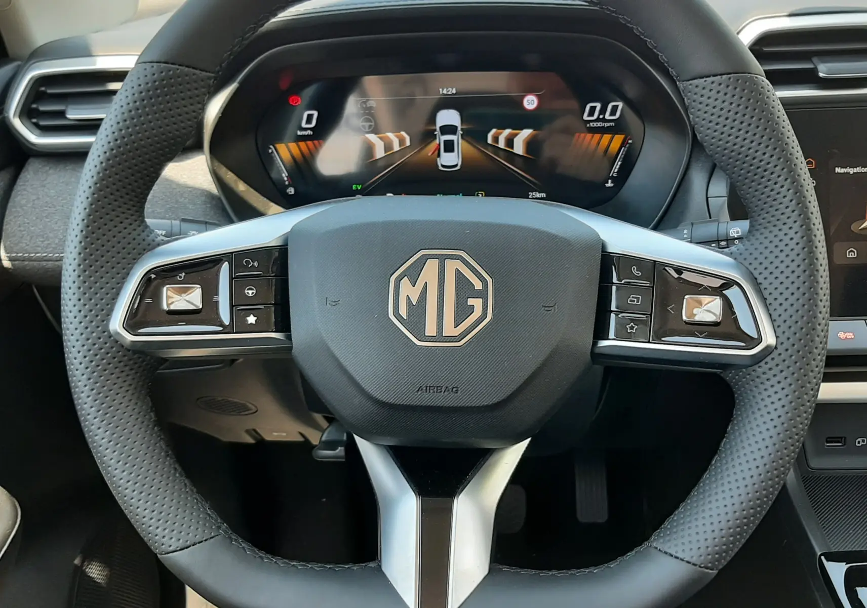 Vue rapprochée du volant noir perforé MG ZS 1.5L Hybrid+ avec tableau de bord numérique et commandes intégrées.