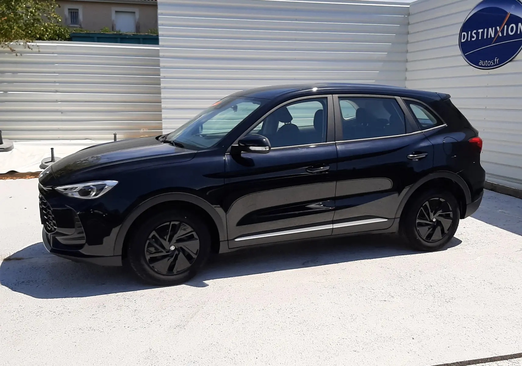 Vue de profil côté gauche du MG ZS 1.5L Hybrid+ 197ch en Pebble Black Metal, avec jantes noires et carrosserie brillante.