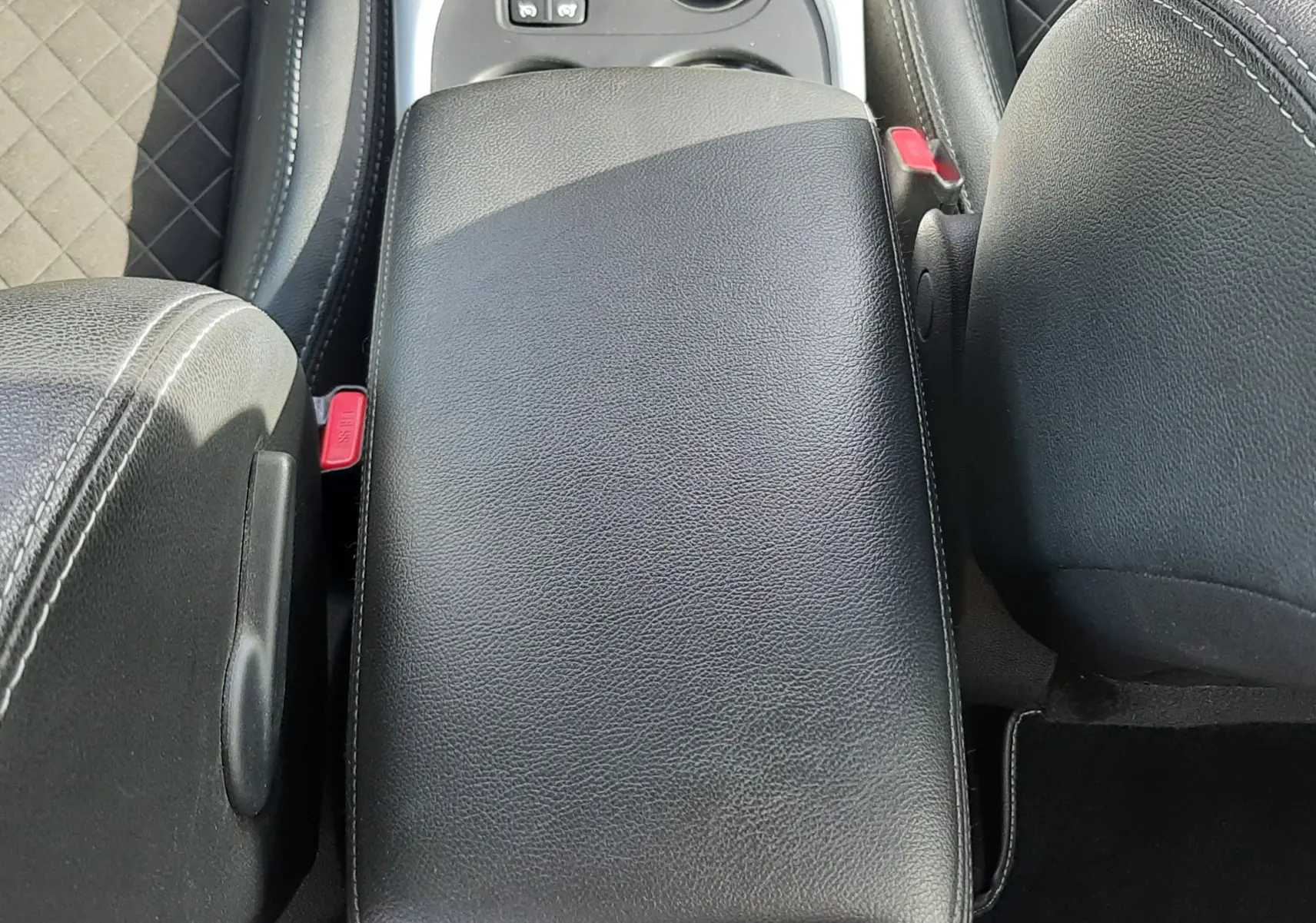 Vue plongeante sur l'accoudoir central en cuir noir et la console centrale du Renault Kadjar 1.5 Blue dCi 115ch Intens 2021.