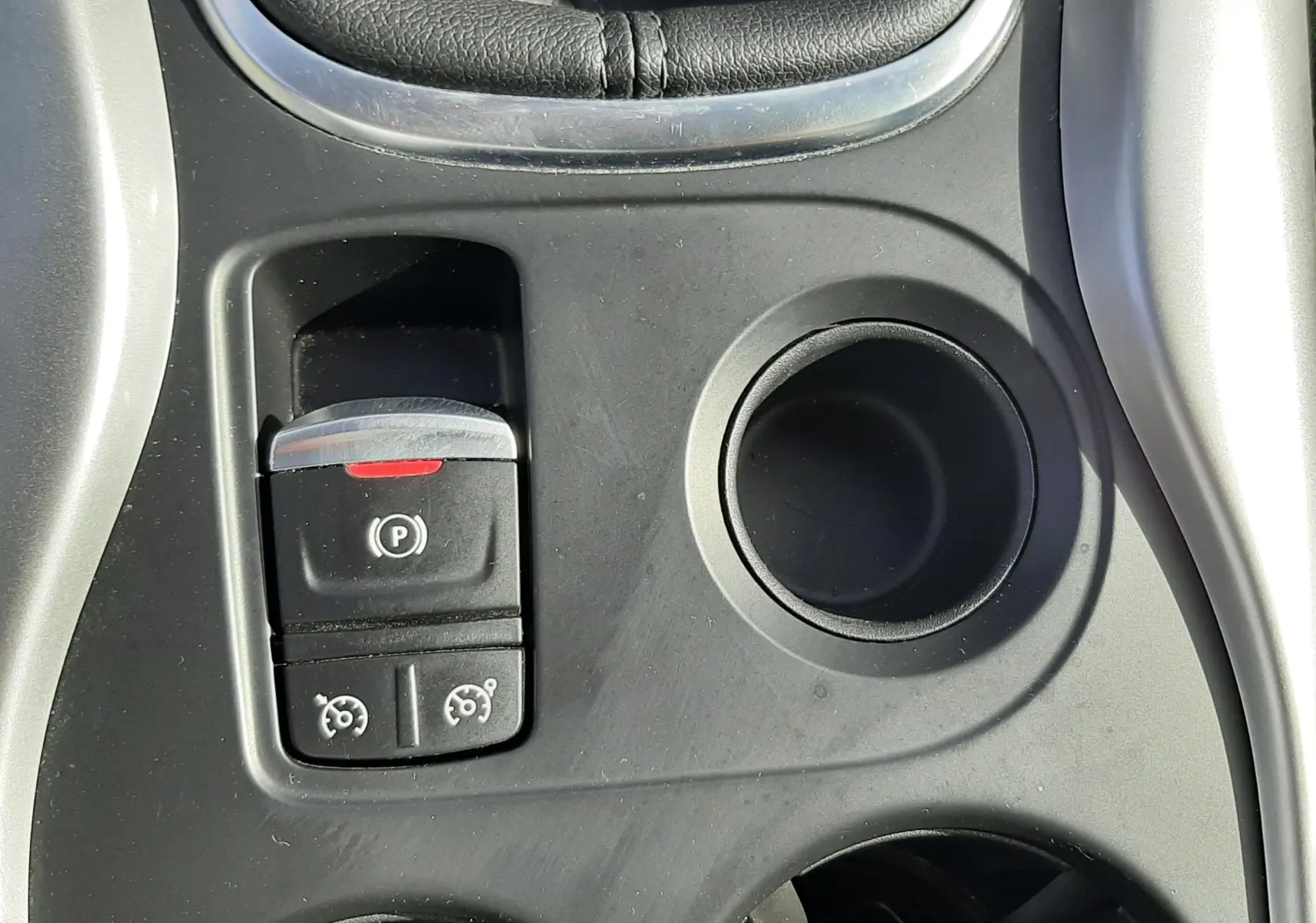 Gros plan sur la console centrale noire du Renault Kadjar 2021, avec frein à main électrique et porte-gobelets.