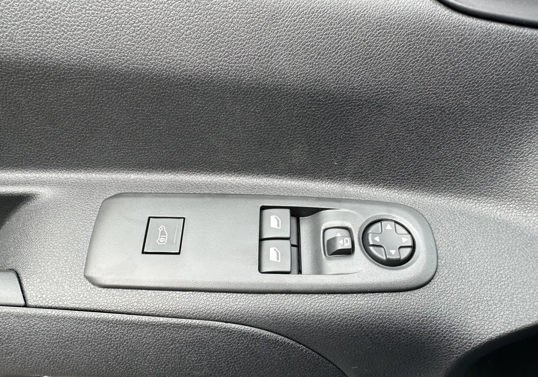 Panneau de commandes des vitres et rétroviseurs côté conducteur du Peugeot Partner Fourgon blanc 2024, intérieur noir.