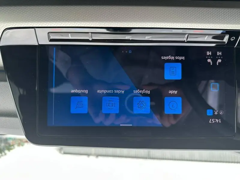 Vue rapprochée de l'écran tactile intérieur de la Volkswagen Golf 2024 noir intense nacré, affichant les réglages du véhicule.