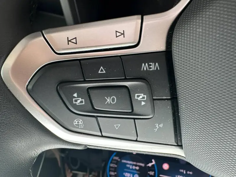 Gros plan sur les commandes multifonctions au volant de la Volkswagen Golf 1.5 eTSI Style 2024, finition noire.