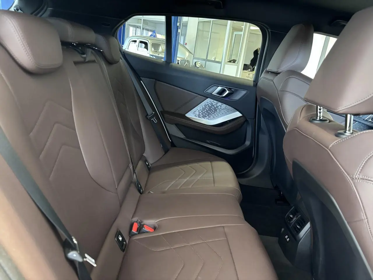 Vue intérieure côté droit des sièges arrière en cuir marron de la BMW Série 1 120d M Sport 2025.