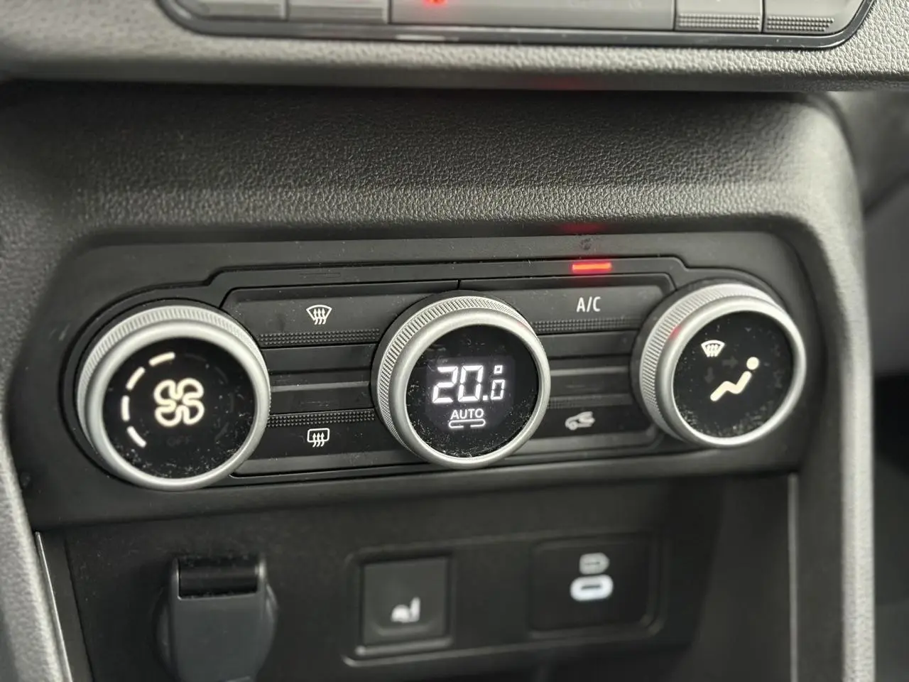 Gros plan sur les commandes de climatisation automatique de la Dacia Sandero Stepway, affichant 20°C.