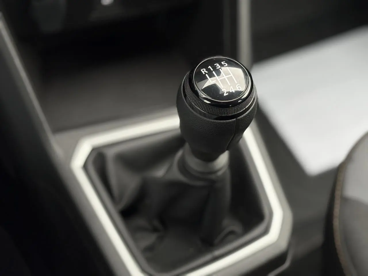 Le levier de vitesses manuel noir de la Dacia Sandero Stepway, vue rapprochée de l'intérieur.