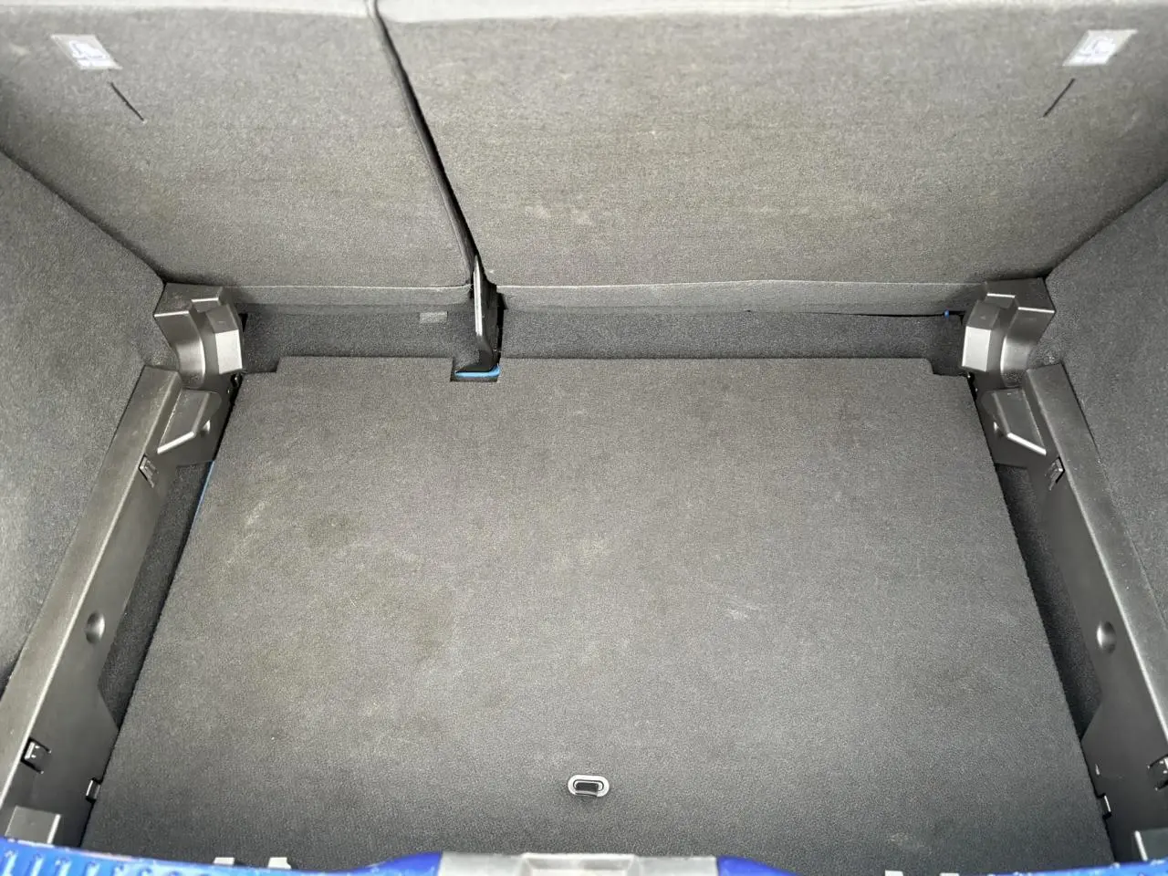 Vue plongeante sur le coffre spacieux de la Dacia Sandero Stepway Bleu Iron, avec banquette arrière rabattue.