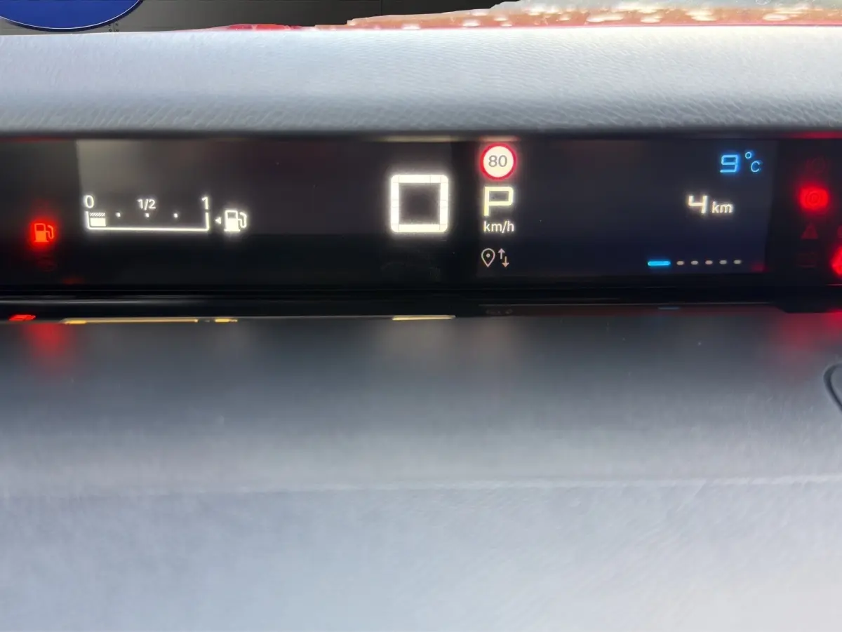 Tableau de bord numérique de Citroën C3 hybride rouge, affichant vitesse, température et niveau carburant.