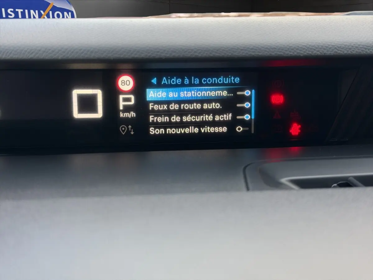 Écran central du tableau de bord de la Citroën C3 hybride rouge, affichant les aides à la conduite activées.