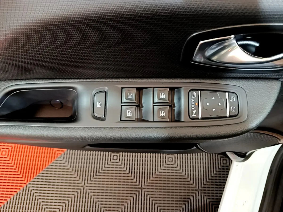 Vue rapprochée de la porte avant gauche blanche d'une Renault Clio Business avec commandes électriques des vitres et rétroviseurs.