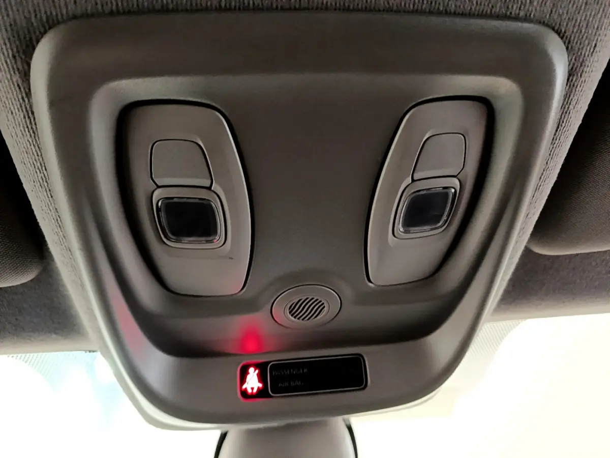 Vue rapprochée du plafonnier gris avec commandes d'éclairage et témoin de ceinture allumé dans une Renault Clio blanche 2019.