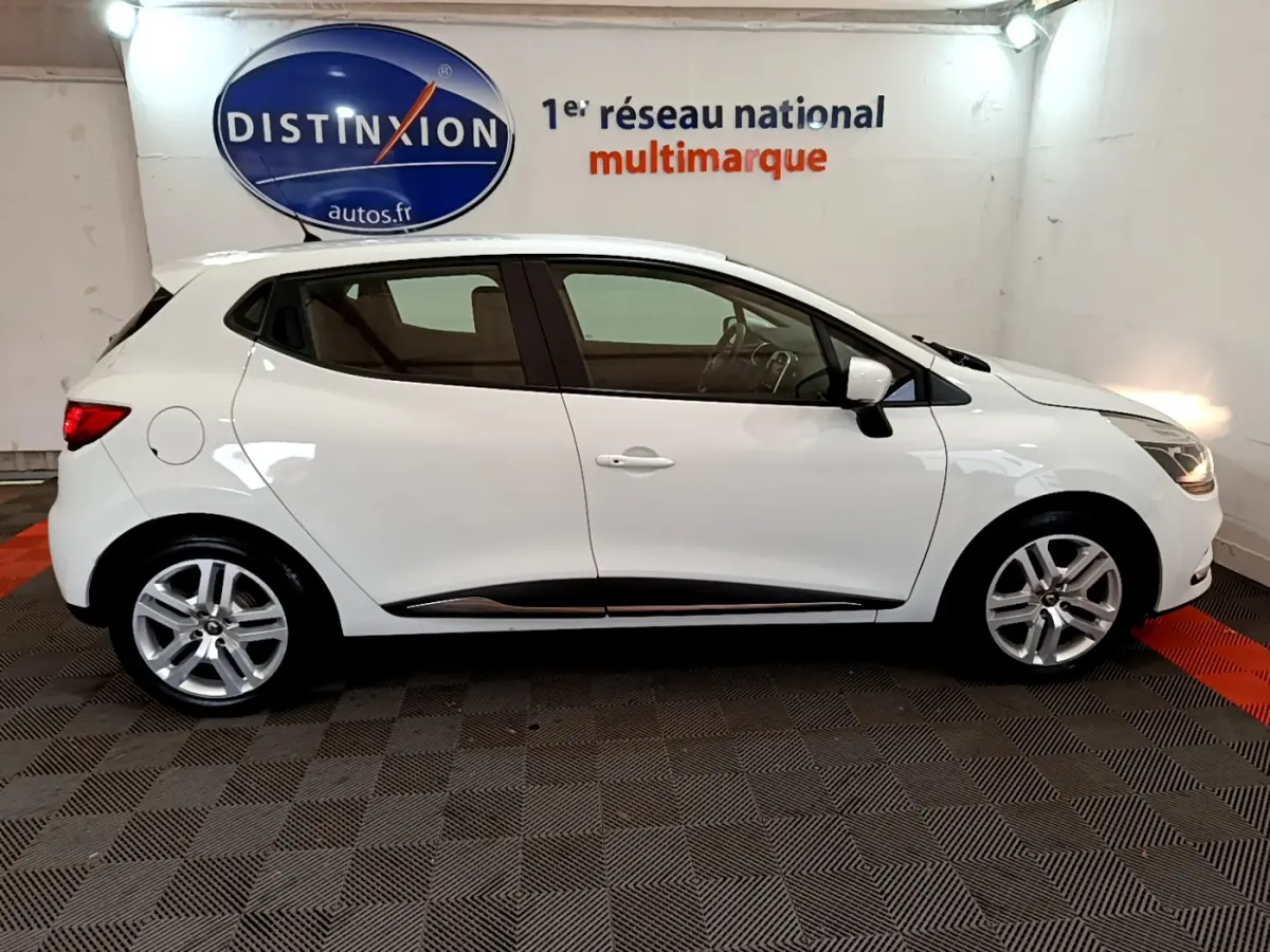 Profil côté gauche d'une Renault Clio Business TCe 90 blanche 2019, avec jantes alliage et rétroviseurs blancs.