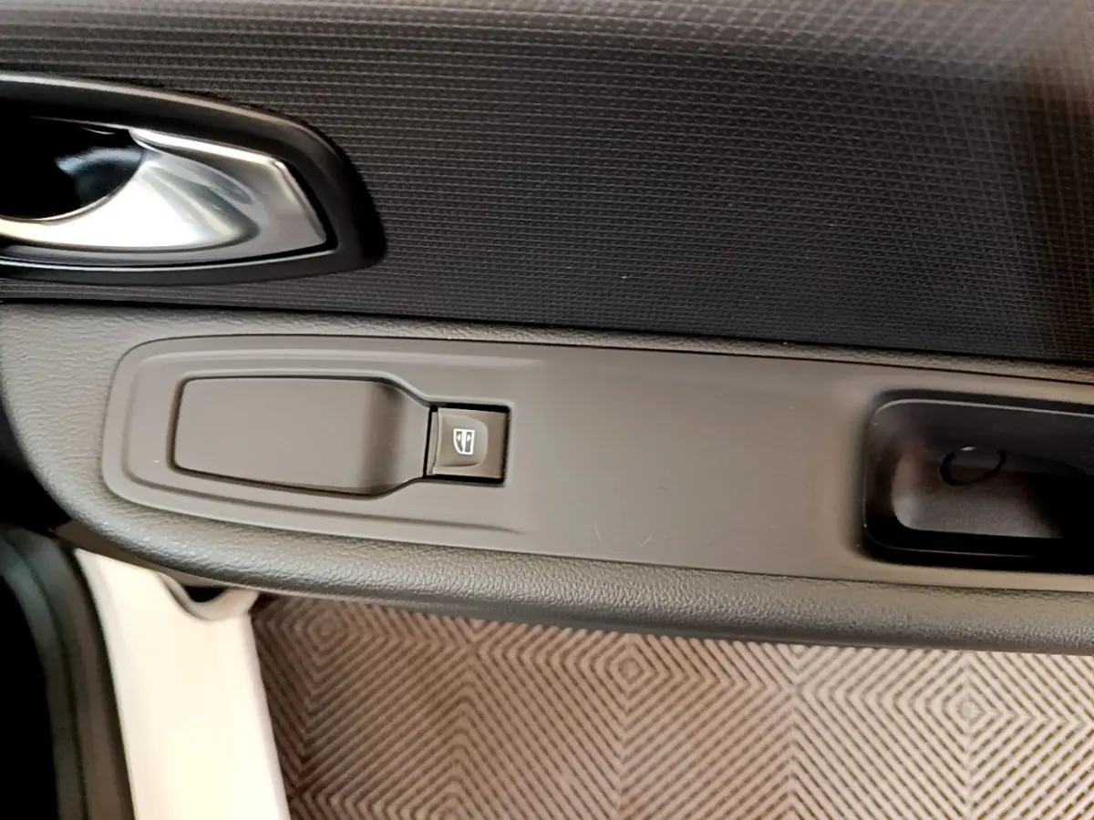 Gros plan sur la commande de lève-vitre côté conducteur de la Renault Clio Business TCe 90 blanche de 2019.