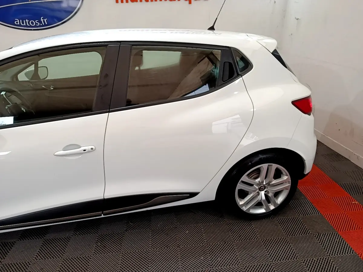 Profil côté gauche d'une Renault Clio Business TCe 90 blanche avec jantes alliage et poignées de porte intégrées.